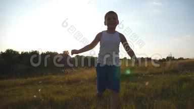快乐的小<strong>男孩</strong>在镜头后的田野里<strong>奔跑</strong>的肖像。 微笑的<strong>男孩</strong>子在夏天的草地上享受大自然的乐趣